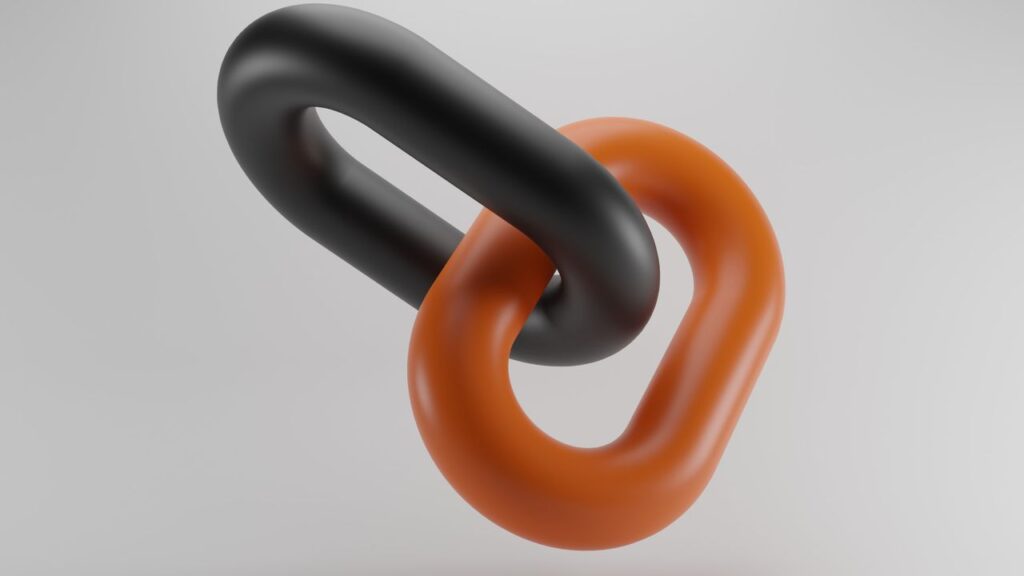 Conceptual image of two linked chains in black and orange, symbolizing connection and strength.